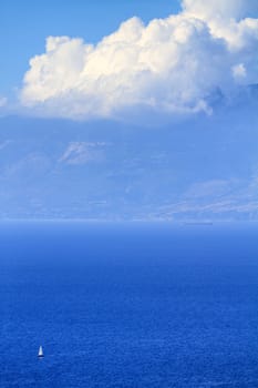 sailing boat traveling in the blue sea of greek islands