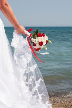 closeup of a bride's wedding bouquet of roses at the beach
