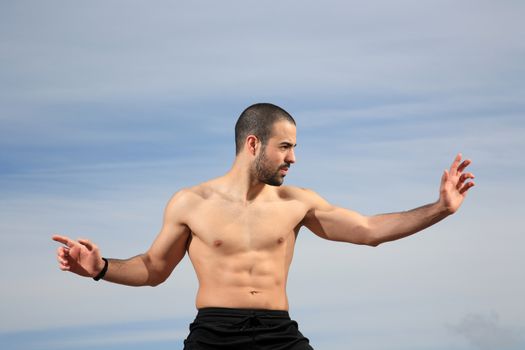 young martial arts instructor exercising on a sand hill