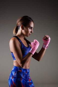 girl kickboxer posing with pink hand wraps
