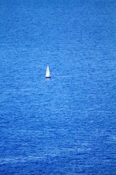 sailing boat traveling in the blue sea of greek islands