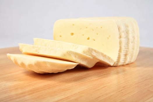 close up of chunk of spicy cheese on a wooden plate