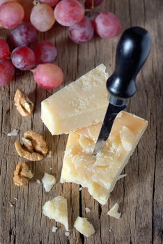 cheese, walnut, and grapes on wooden table