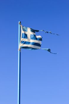 destroyed from the wind greek flag on a blue sky with clouds