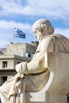 greek ancient statue and the greek flag in the background