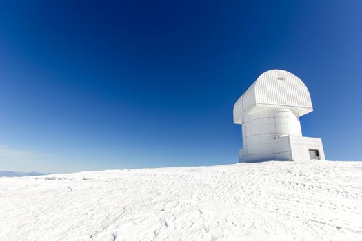 small observatory on the top of a mountain with snow