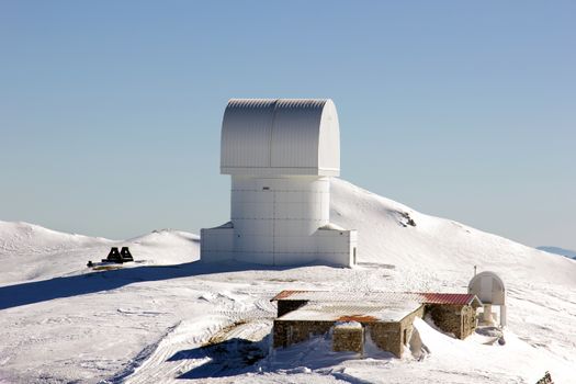 small observatory on the top of a mountain with snow