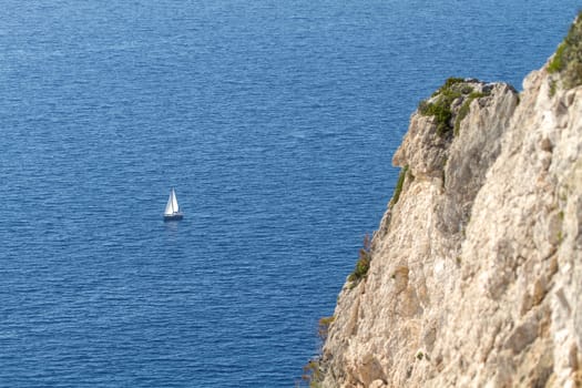 sailing boat traveling in the blue sea of greek islands