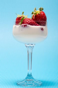 fresh strawberries on a glass filled with cream 
