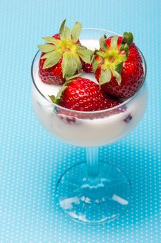 fresh strawberries on a glass filled with cream 