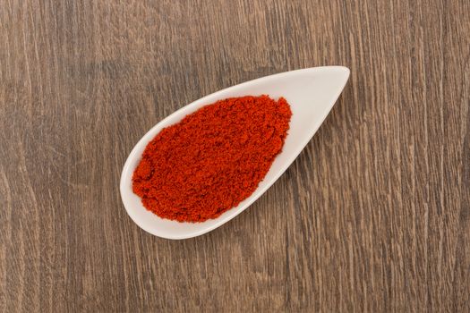 Red pepper powder over wood background texture