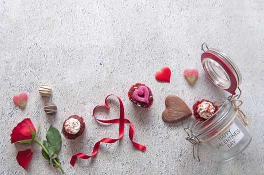 Heart, chocolates, flowers and gifts pouring out of a valentines day jar 