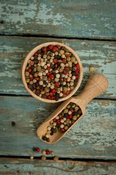 Mixed peppercorns in a wooden bowl.