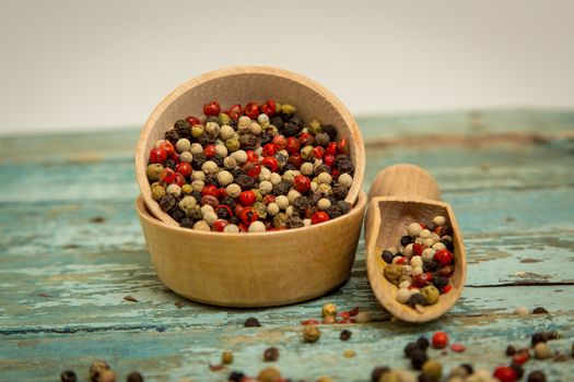 Mixed peppercorns in a wooden bowl.