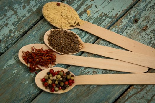 Saffron, pepper, cumin and mustard in a wooden spoons