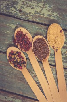 Saffron, pepper, cumin and mustard in a wooden spoons