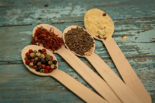 Saffron, pepper, cumin and mustard in a wooden spoons