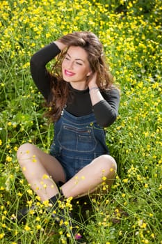 portrait of a beautiful young girl among yellow flowers in the nature