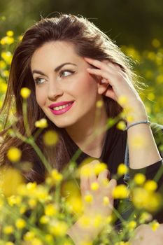 portrait of a beautiful young girl among yellow flowers in the nature