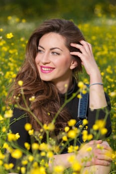 portrait of a beautiful young girl among yellow flowers in the nature