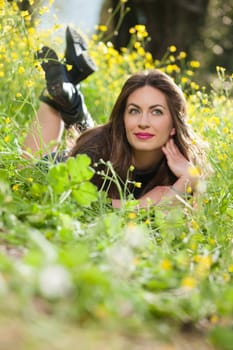 portrait of a beautiful young girl among yellow flowers in the nature