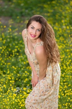 portrait of a beautiful young girl among yellow flowers in the nature