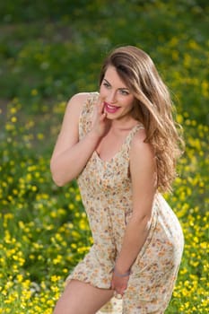 portrait of a beautiful young girl among yellow flowers in the nature