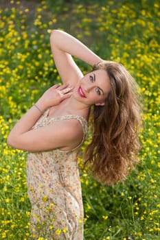 portrait of a beautiful young girl among yellow flowers in the nature