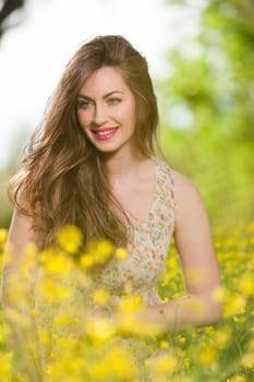 portrait of a beautiful young girl among yellow flowers in the nature