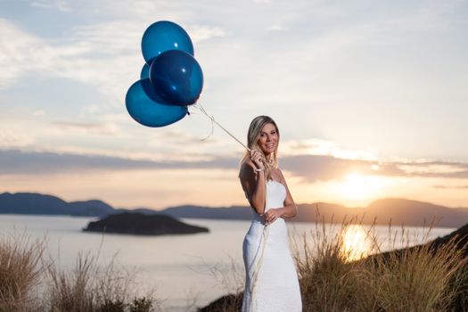 portrait of a beautiful bride with balloons enjoy the sunset in the nature