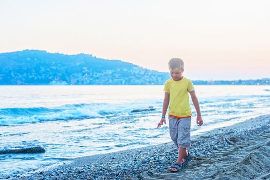 Kid boy walking at Alania beach, Turkey