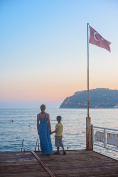 mother and son on the pier in the evening at Alania, Turkey