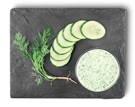 Cucumber smoothie top view. Cucumber, dill, cottage cheese whipped in a glass on a slate stone.