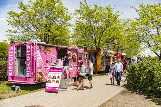 Montreal, Canada - May 28, 2017: People walking outside looking for some street food during a bright sunny day, on May 28, 2017 in Montreal Canada