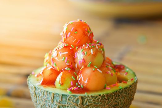 Ice cream cantaloupe with topping in cantaloupe.