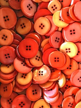 Background of plastic red and orange buttons.