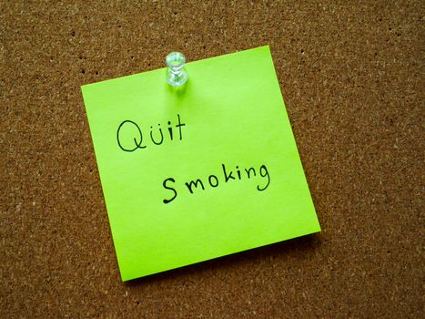 Quit smoking on post it note for remind on wooden board