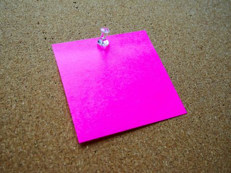 Pink post it note on wooden board