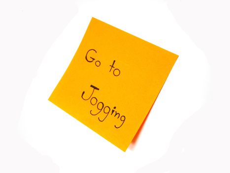 Writting "Go to jogging" on post it note for reminder