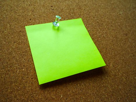 Green post it note on wooden board 