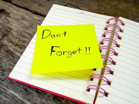 Focus reminder paper note in note book on wooden table 