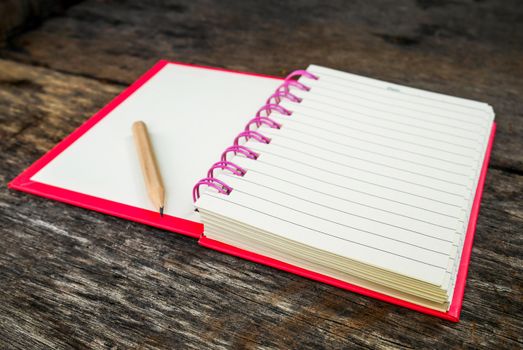 Note book with pencil on wooden table with selective focus