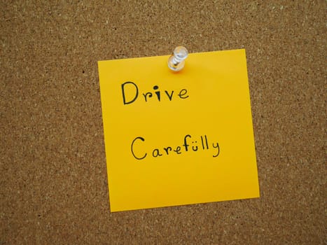 Drive carefully in post note on wooden board