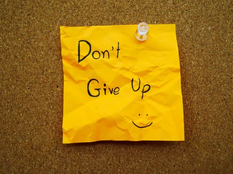 Don't give up in post note on wooden board