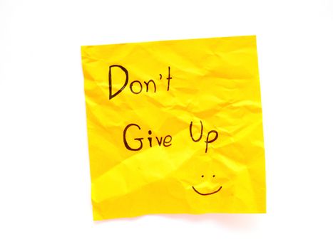 Write don't give up on yellow post note isolated on white background