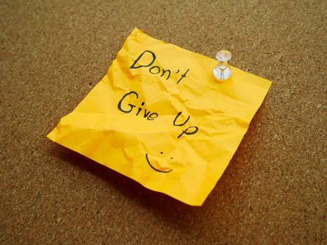 Don't give up in post note on wooden board