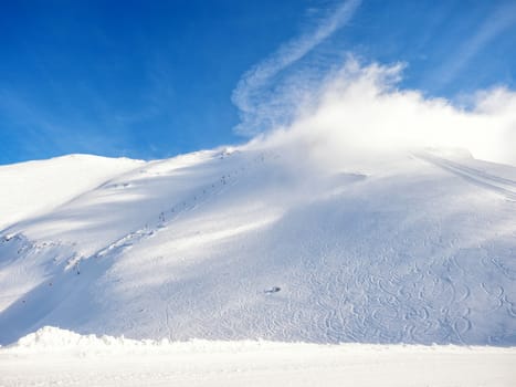 Clouds cover the lifts on top of the mountain in Kalavrita ski resort in a sunny day