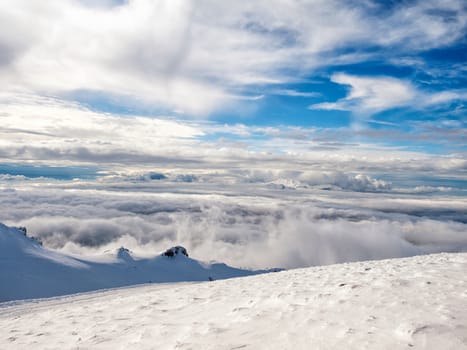 The top of the mountain Helmos in Kalavrita ski resort with snow and clouds in a sunny day