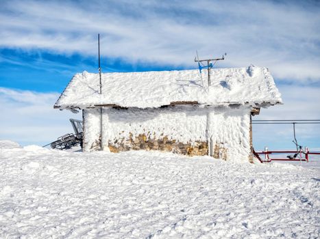 Frozen small meteorological station at the top of the mountain Helmos in Kalavrita ski resort  in a sunny day