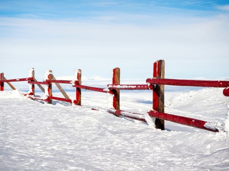Red frozen fence at  the top of the mountain Helmos in Kalavrita ski resort in a sunny day
